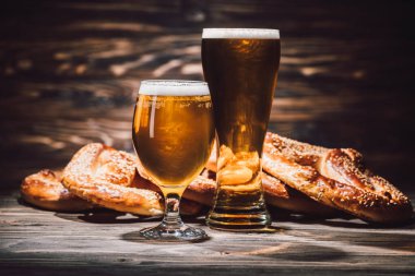 İki bardak taze bira ve ahşap masa, oktoberfest kavramı üzerinde lezzetli simit