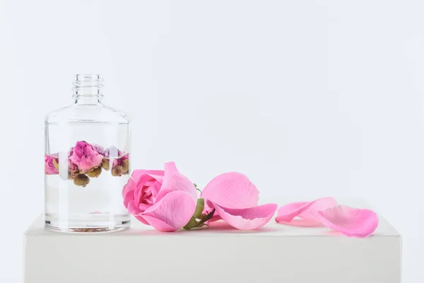 Bottiglia Olio Essenziale Aromatico Con Rose Rosa Superficie Bianca — Foto Stock