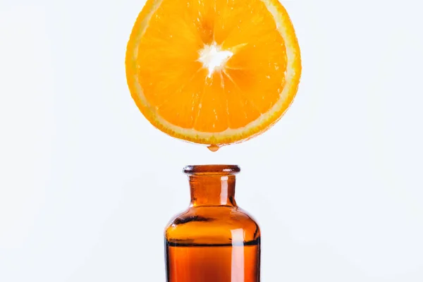 橙片芳香汁滴入天然草本精油瓶中白色 — 图库照片