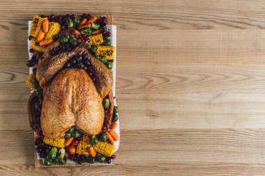 top view of roasted turkey and vegetables for thanksgiving traditional dinner on wooden tabletop