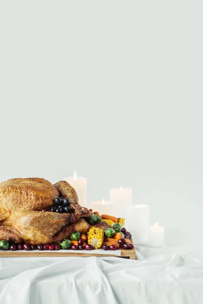 特写蜡烛 节日火鸡与烤蔬菜的节日晚餐桌面上的灰色背景 感恩节假期概念 — 免费的图库照片