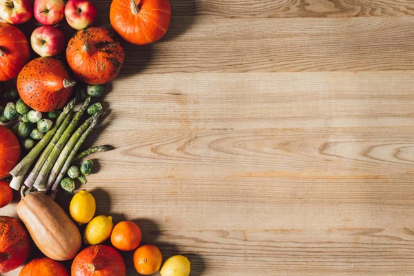 top view of arranged fresh autumn vegetables and fruits on wooden surface
