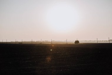 Doğal görünümü alan ve gün batımı sırasında kırsalında elektrik kuleleri 