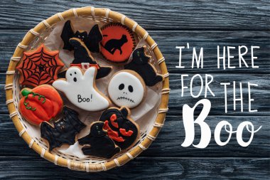 top view of wicker basket with homemade spooky halloween cookies on wooden table  with 
