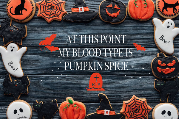frame made of spooky halloween homemade cookies on black wooden background with "at this point my blood type is pumpkin spice" lettering