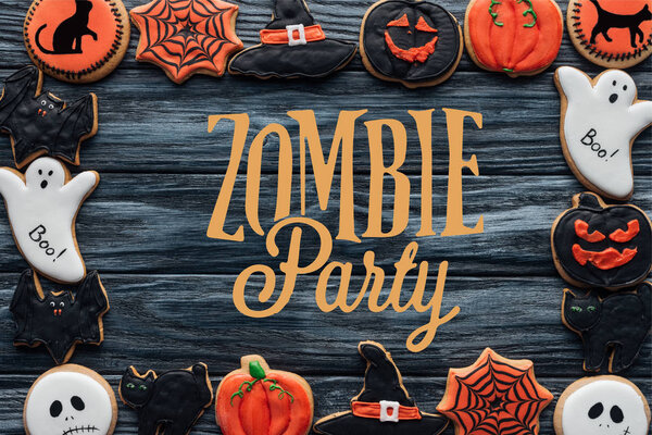 frame made of spooky halloween homemade cookies on black wooden background with "zombie party" lettering