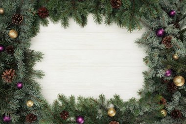 güzel herdem yeşil çam çırpı parlak baubles ve çam kozalakları ile üstten görünüm Beyaz ahşap zemin üzerinde  