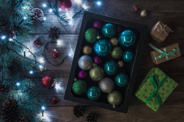 üstten görünüm Noel hediyeleri, parlak baubles ve köknar ahşap arka plan aydınlatılmış garland ile çırpı 