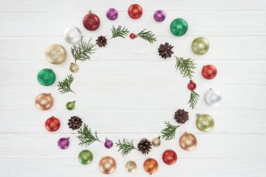 ahşap yüzey, Noel arka plan üzerinde güzel parlak renkli baubles, iğne yapraklı twigs ve çam kozalakları üstten görünüm 