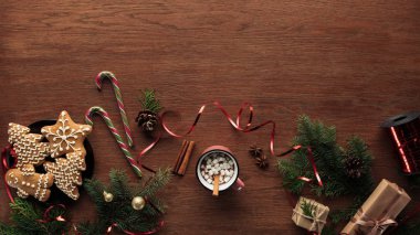 düz lay ile sıcak çikolata şekerleme, tarçın ve Noel dekorasyonları ahşap arka plan üzerinde
