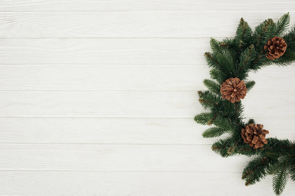 top view of beautiful christmas wreath on white wooden background