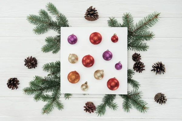 Top View Shiny Colorful Christmas Balls White Card Fir Twigs — Stock Photo, Image