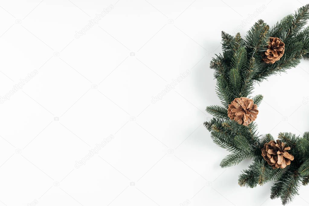 close-up view of beautiful christmas wreath with pine cones on white background