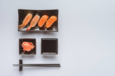somon ve karides, zencefil, soya sosu ve yemek çubukları beyaz izole lezzetli suşi üstten görünüm 