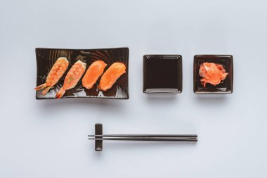 gurme suşi somon ve karides, zencefil ve üzerinde beyaz izole yemek çubukları üstten görünüm    