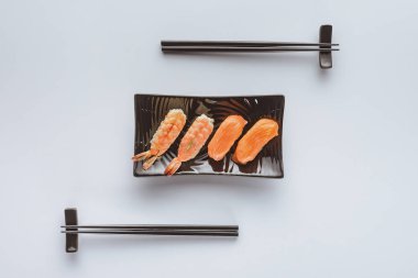 somon ve karides lezzetli suşi üstten görünüm plaka ve yemek çubukları beyaz izole