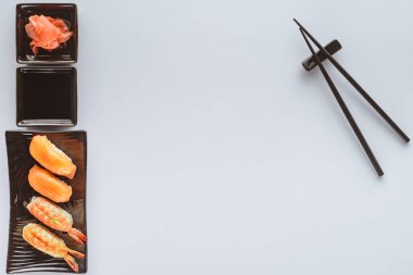 somon ve karides, zencefil ve beyaz arka plan üzerinde izole yemek çubukları ile lezzetli suşi üstten görünüm 
