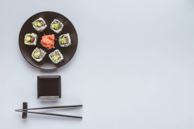 top view of delicious sushi with ginger and chopsticks isolated on white  clipart