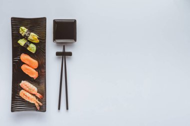 çeşitli gurme suşi ve üzerinde beyaz izole yemek çubukları üstten görünüm