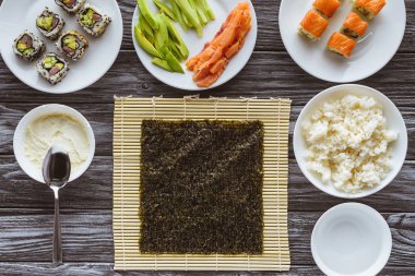 nori ve ahşap masa üzerinde suşi yemek için lezzetli maddeler üstten görünüm