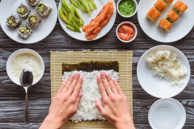 suşi pirinç ve nori, masaya gurme malzemeler ile hazırlama kişinin kısmi üstten görünüm  