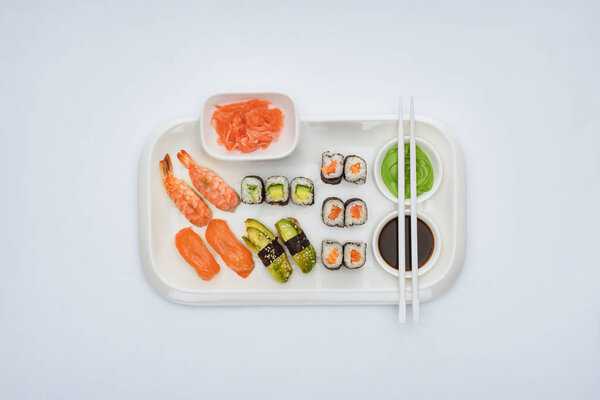 top view of delicious sushi set with chopsticks isolated on white 