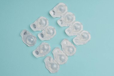 Düzenlenmiş mavi zemin üzerine beyaz kaplarda kontakt lensler ile düz lay