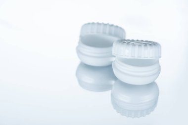 close up view of empty container for contact lenses on white backdrop with reflection clipart