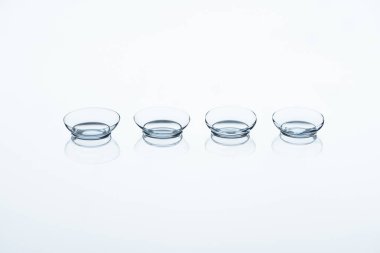 close up view of contact lenses arranged on white backdrop clipart