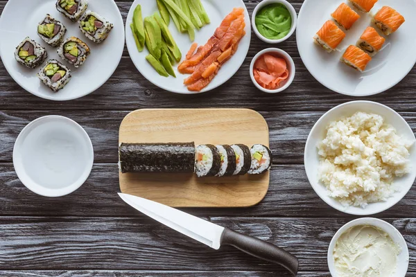 Bovenaanzicht Van Heerlijke Gesneden Sushi Roll Mes Ingrediënten Houten Tafel — Stockfoto