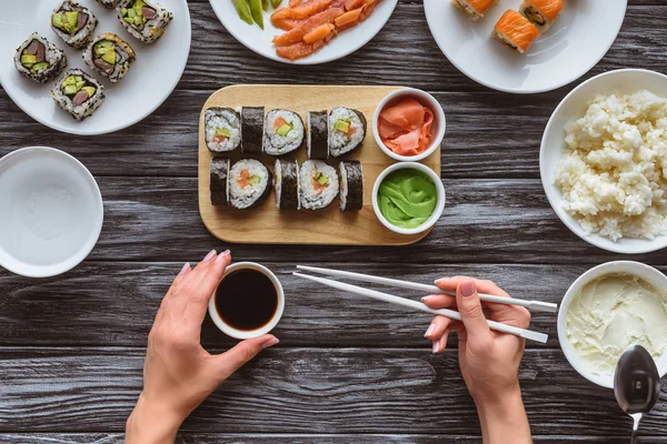 手持筷子和吃美味寿司的人被裁掉的镜头 — 图库照片