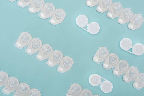 top view of contact lenses in containers arranged on blue background