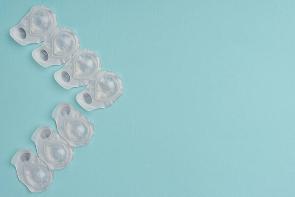 flat lay with contact lenses in white containers arranged on blue background