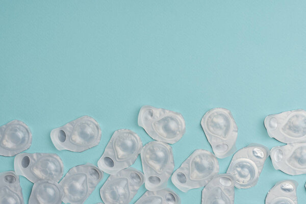 flat lay with contact lenses in containers arranged on blue background