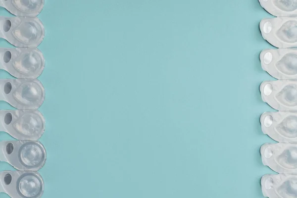 青色の背景色に配置されたコンテナーのコンタクト レンズとフラット レイアウト  — 無料ストックフォト