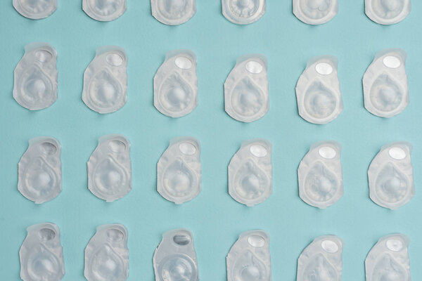 flat lay with contact lenses in containers arranged on blue background
