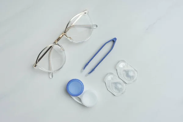 Flat Lay Eyeglasses Contact Lenses Containers Tweezers Arranged White Surface — Stock Photo, Image