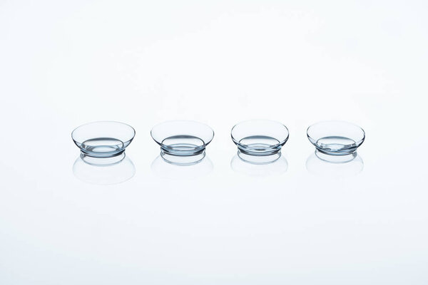 close up view of contact lenses arranged on white backdrop