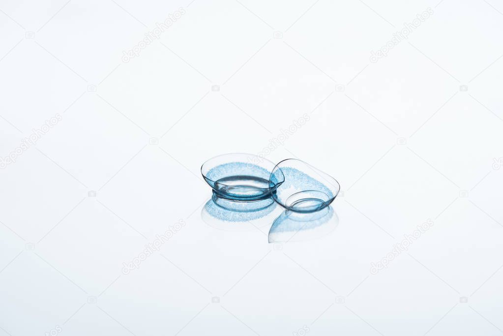 close up view of contact lenses arranged on white backdrop