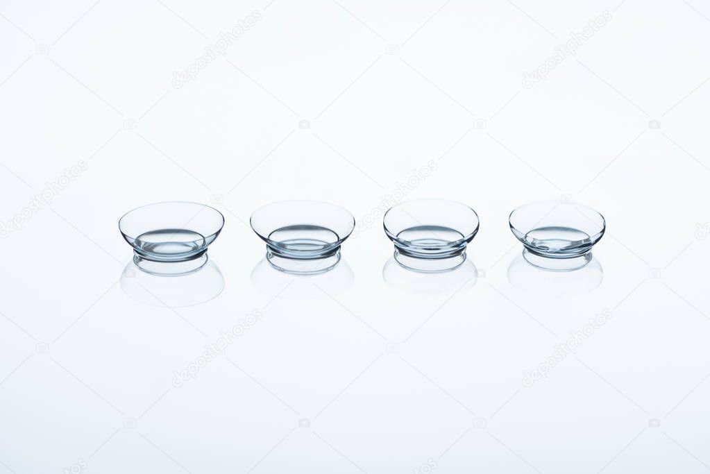 close up view of contact lenses arranged on white backdrop
