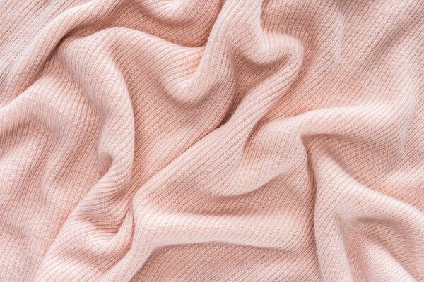 full frame of pink folded woolen fabric background