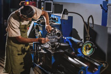 koruyucu önlük fabrikasında makine aracını kullanarak erkek üretim işçisi