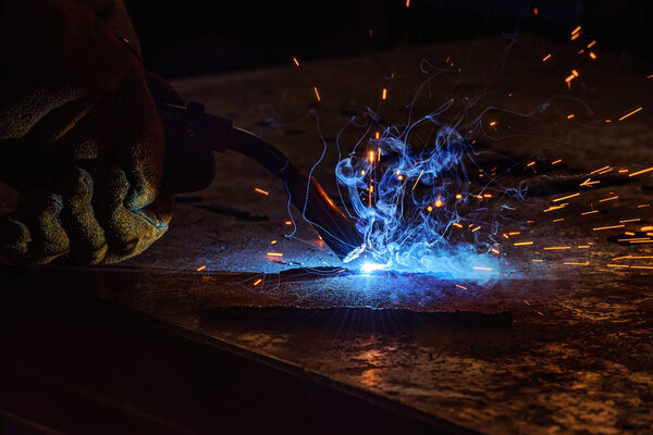 обрезанное изображение сварщика паяльного металла с искрами на заводе
 