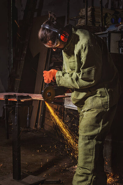 manufacture worker in protective googles working with circular saw at factory