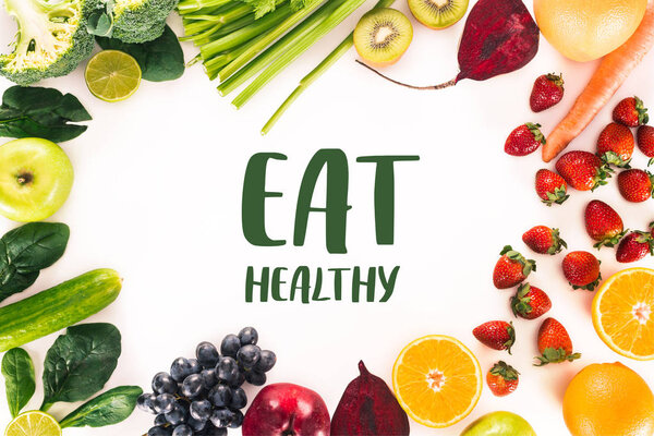 top view of arrangement with fresh vegetables, fruits and berries isolated on white with "eat healthy" lettering