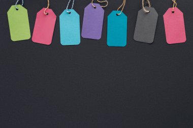 top view of colorful sale tags on black background with copy space for black friday   clipart
