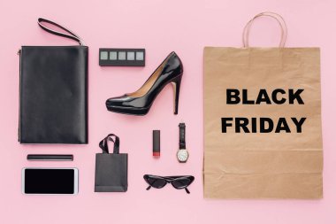 flat lay with accessories and shopping bag with black friday sign isolated on pink clipart