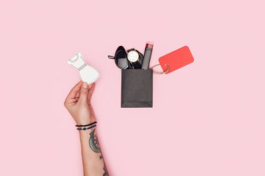 Kırpılan kağıt elbise yakınındaki küçük alışveriş çantası aksesuar ve satış etiketi için siyah Cuma pink izole tutan kız görünümünü