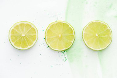 üç yuvarlak adet olgun Limes yeşil suluboya ile beyaz yüzey üzerinde yukarıdan