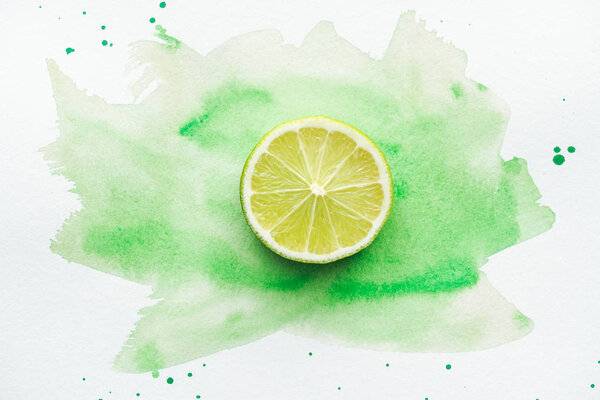 вид сверху на кусок спелых цитрусовых на белой поверхности с зеленой акварелью
